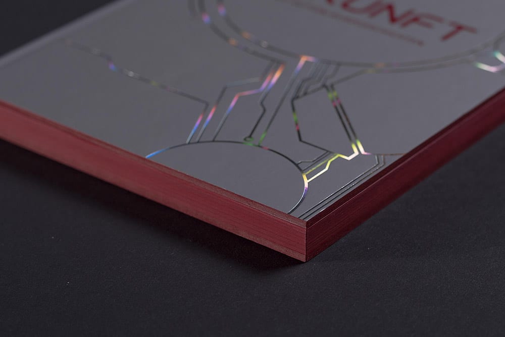 Es ist ein Ausschnitt eines hochwertig gedruckten und mit Folie und Farbschnitt veredelten Buches zu sehen