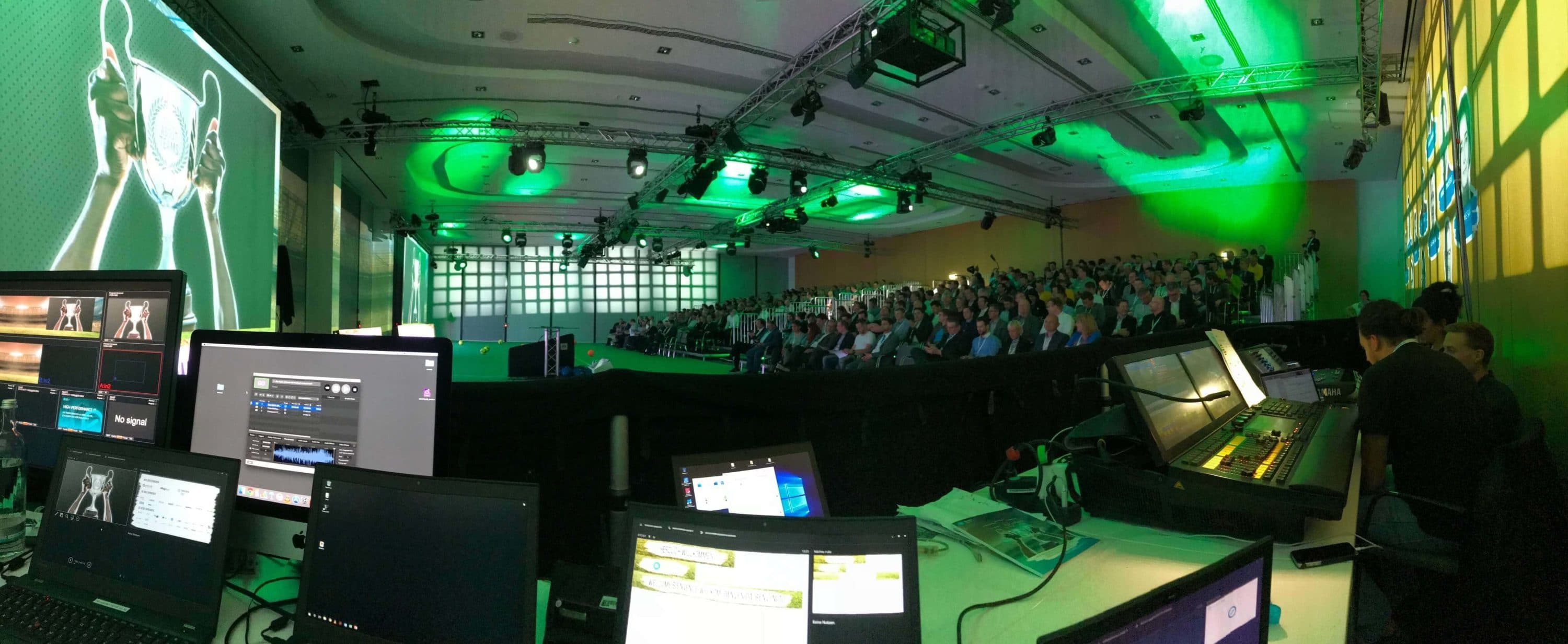 Vollbesetzter Hörsaal beim Kongress mit großem Keyvisual auf der Leinwand