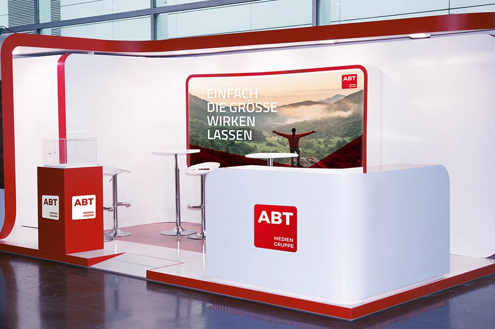 Es ist ein Messestand zu sehen bei dem Plakate und Displays auf eine Druckerei gebranded sind