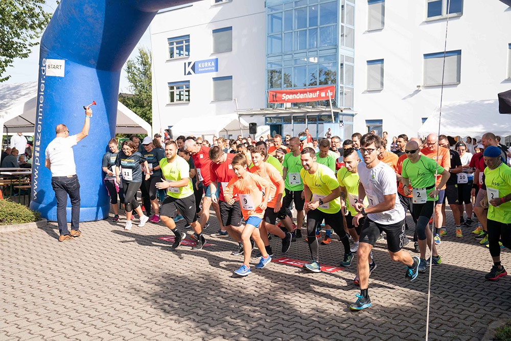 Es ist der Start des ABT Spendenlaufs 2019 zu sehen. Nach dem Startschuss rennt die Menschenmasse los.